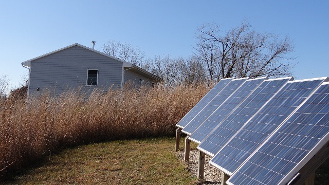 Several solar panels, with Steve Beaumont's house in the background.