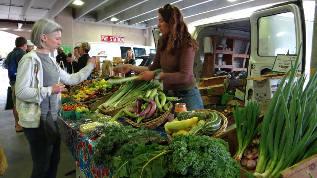 Farmer presenting vegetables to customer